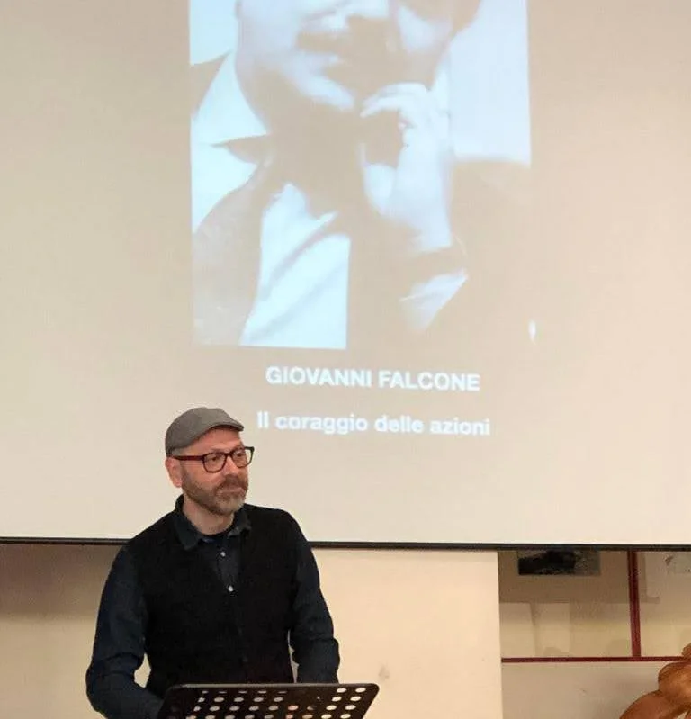 Fabrizio Palma in scena davanti alla proiezione con il ritratto di Giovanni Falcone